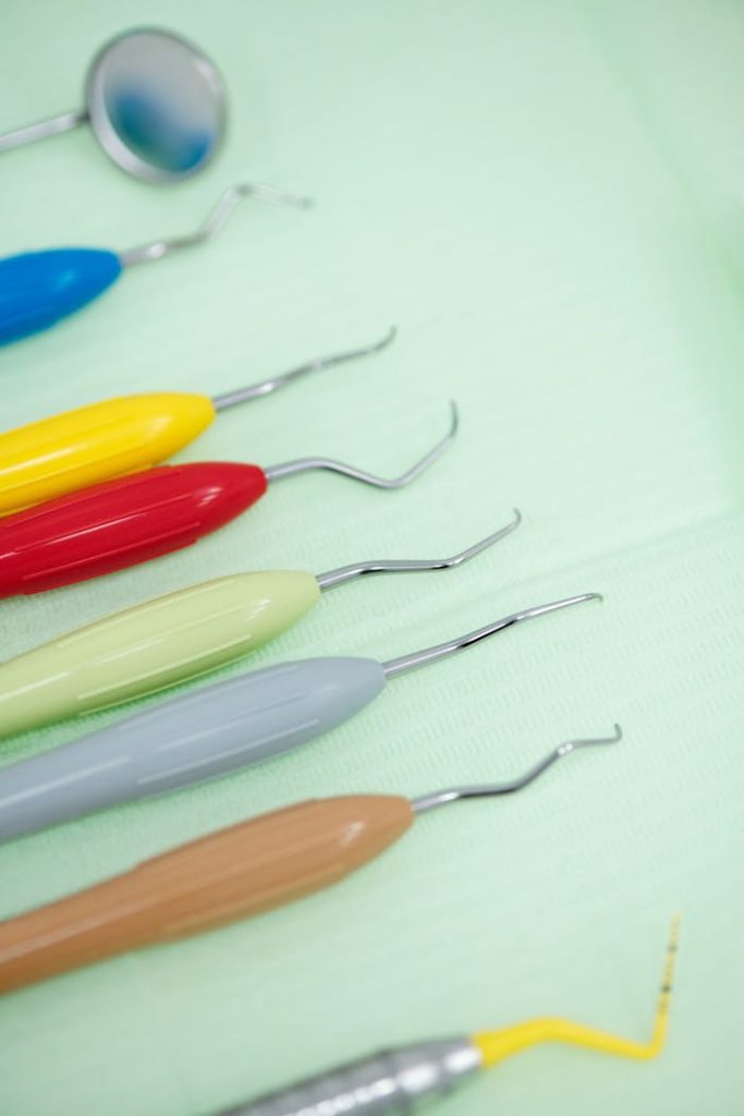 Close-up of colorful dental tools arranged on a green cloth, emphasizing dental care.